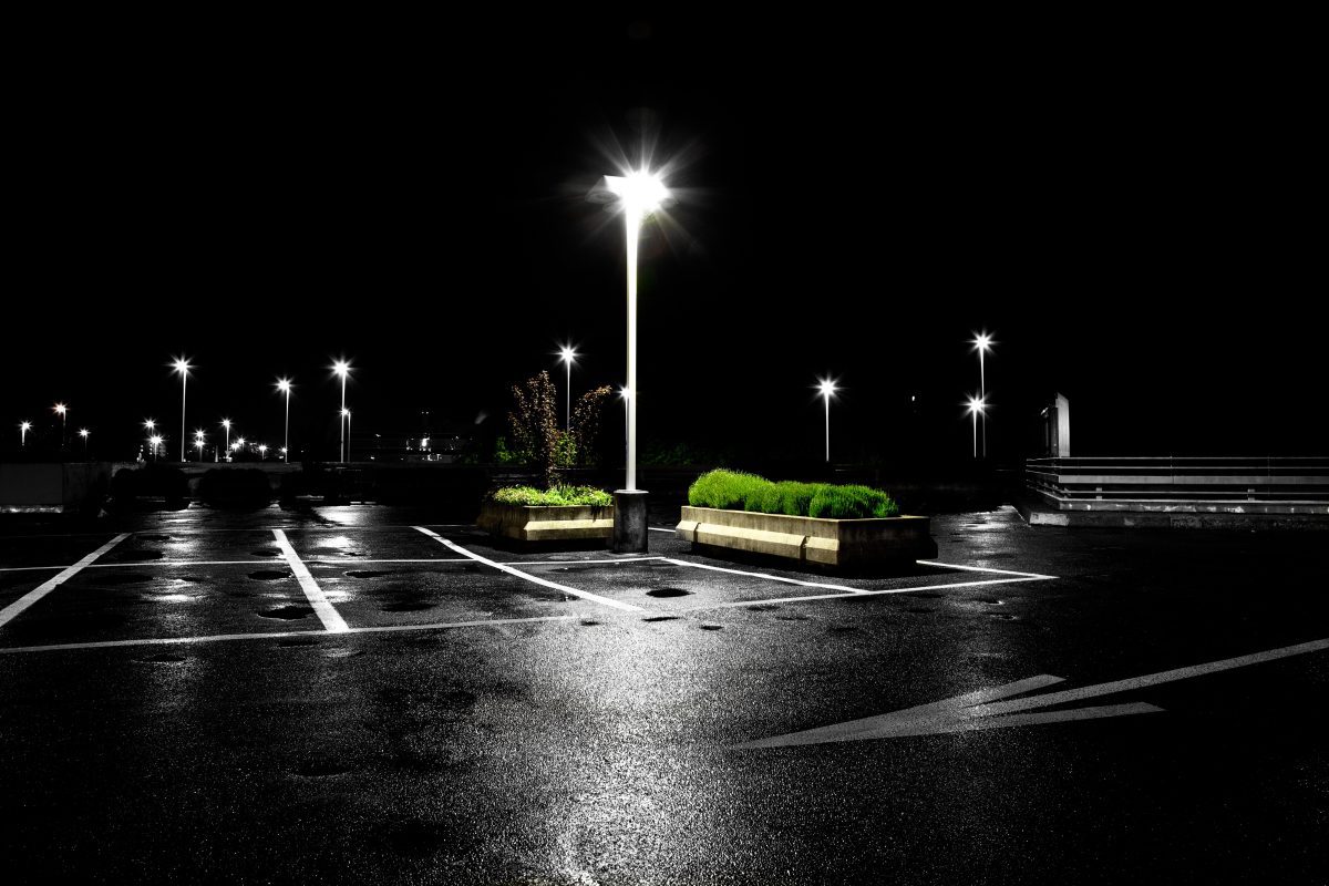 a parking lot at night with bright, white lights illuminating the blacktop