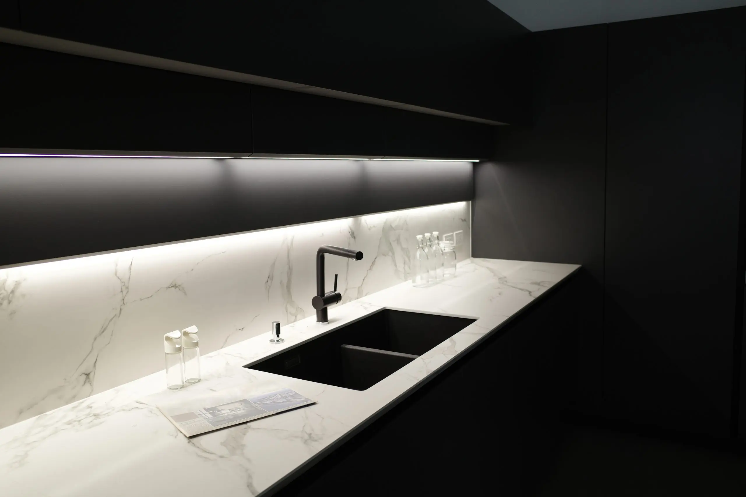 Modern kitchen with marble countertop and under-cabinet lighting illuminating workspace